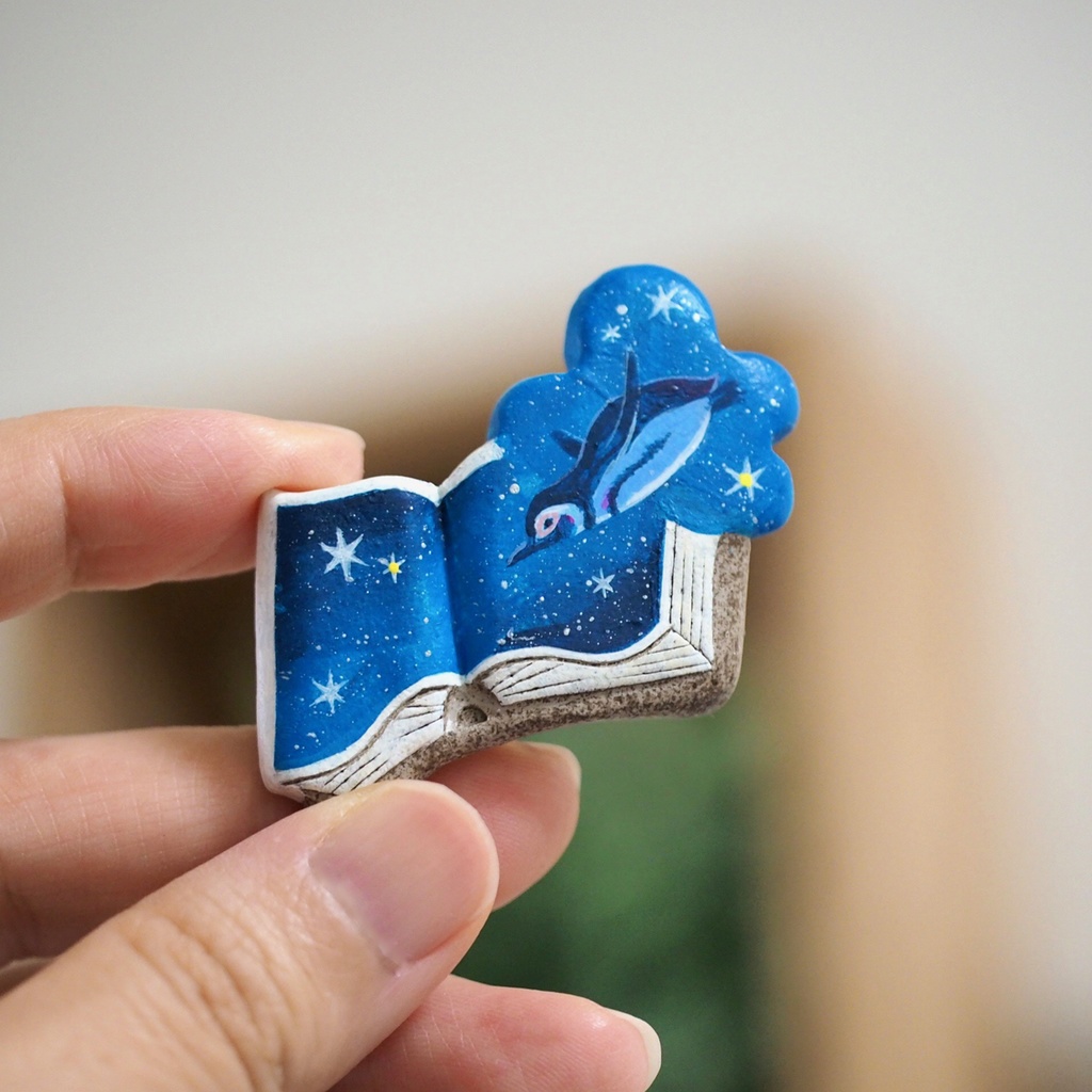 絵本ブローチ《夜空飛ぶペンギン》【手描きイラスト・陶土ブローチ】