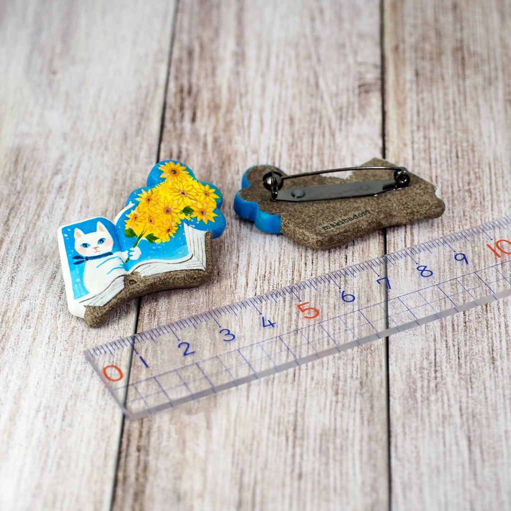 絵本ブローチ《ヒマワリの君に〜白猫》【手描きイラスト・陶土ブローチ】