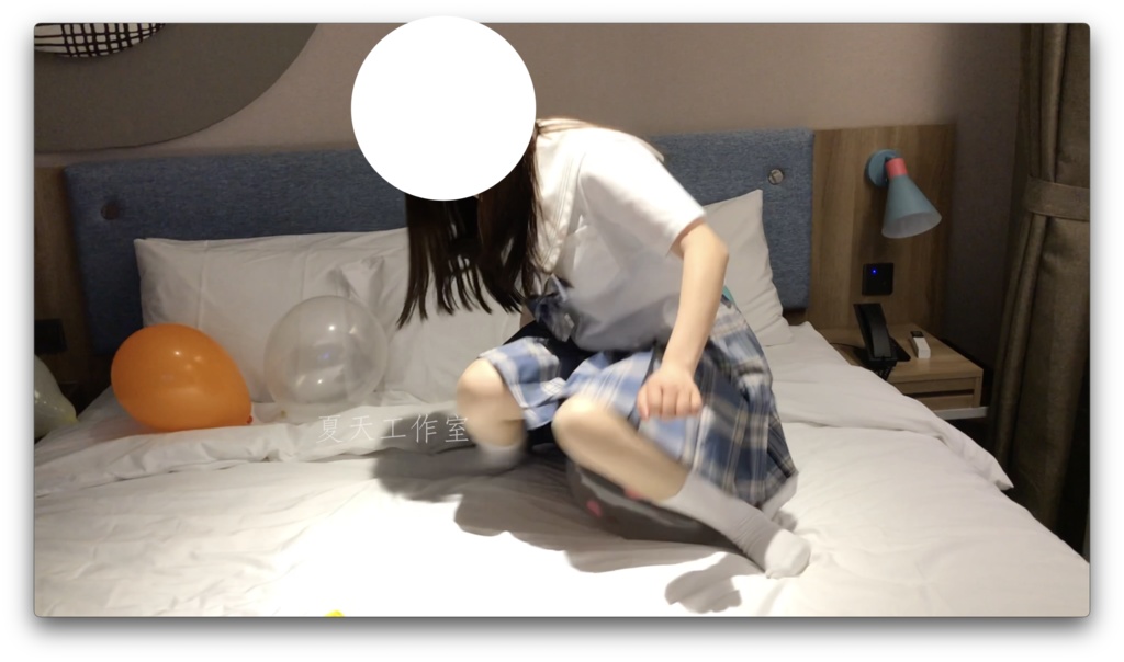 優しい女の子は足で風船遊びをしています。