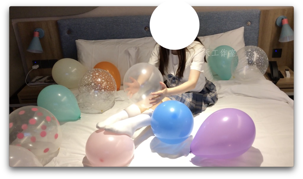 優しい女の子は足で風船遊びをしています。