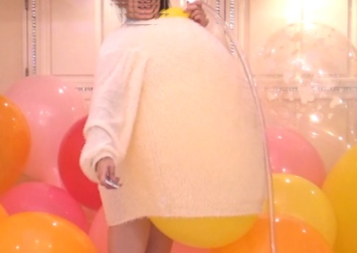 彼女は楽しんで風船の衣服内割りしている