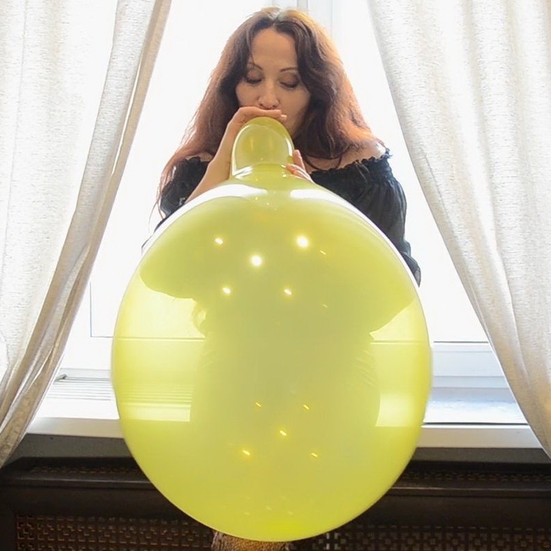 Nathalie Blows To Pop Yellow Balloon