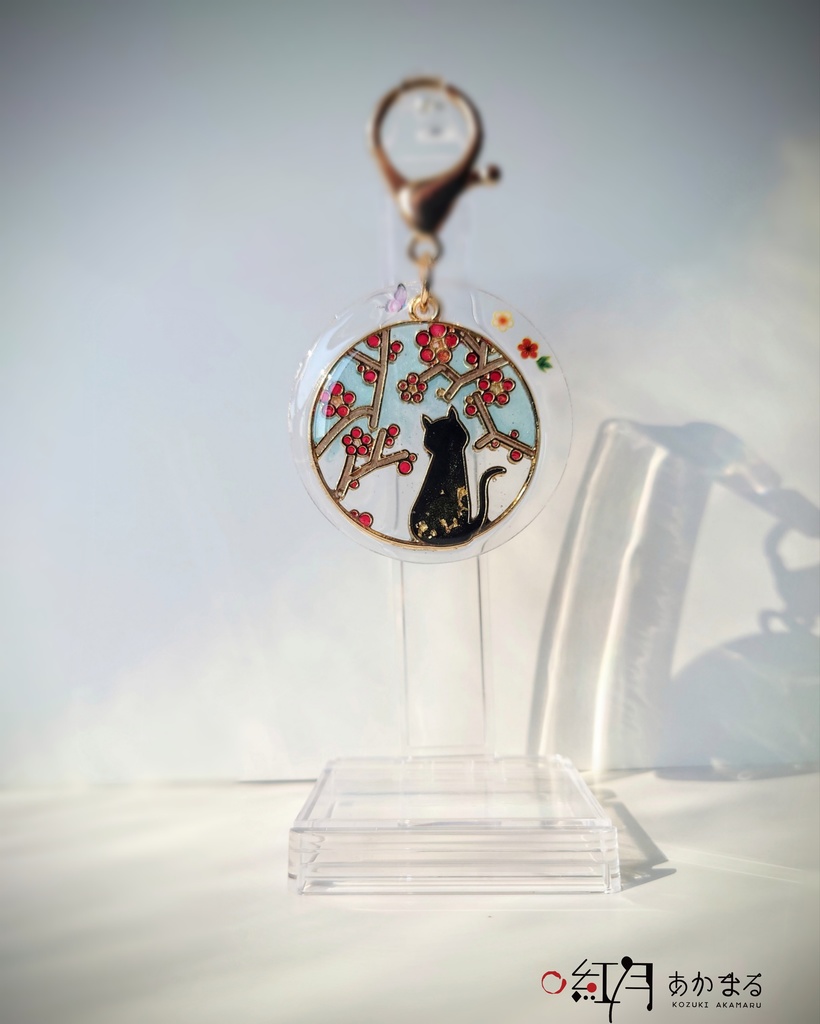 『梅を眺める猫』