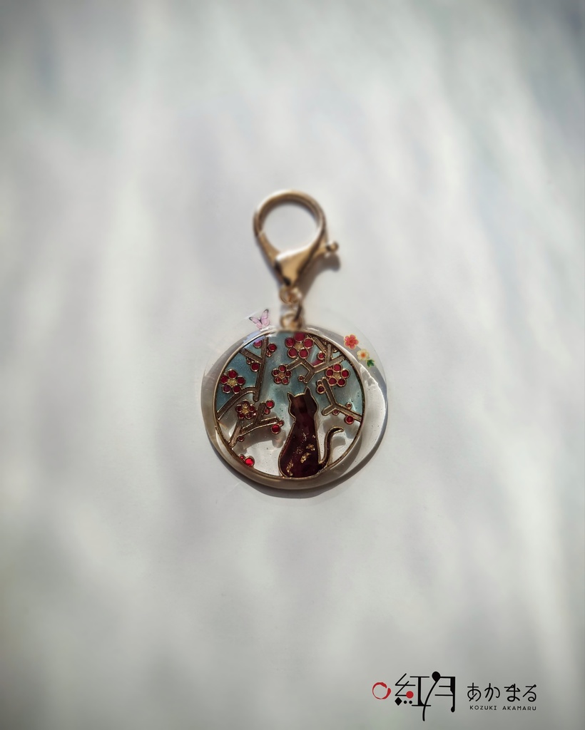 『梅を眺める猫』