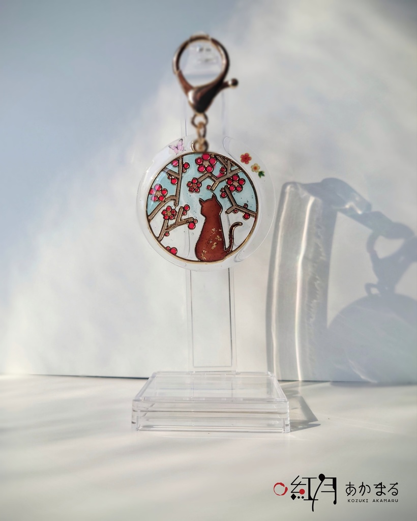 『梅を眺める猫』