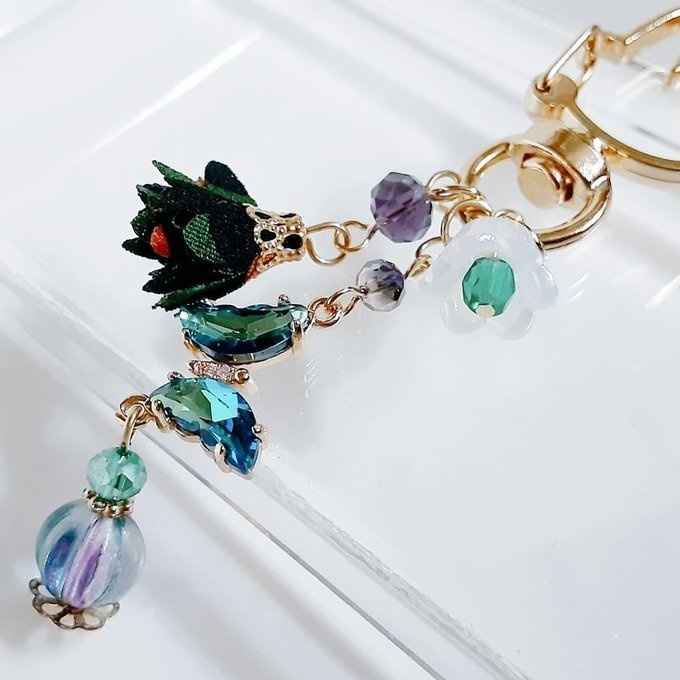 ブルーグリーン色のクリスタル蝶とフラワータッセルとすずらんビーズのお洒落キーホルダー