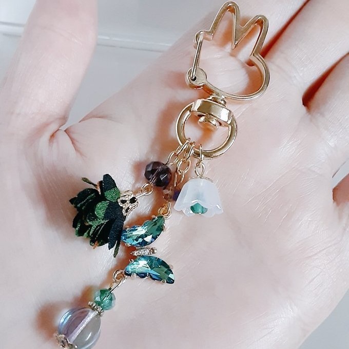 ブルーグリーン色のクリスタル蝶とフラワータッセルとすずらんビーズのお洒落キーホルダー