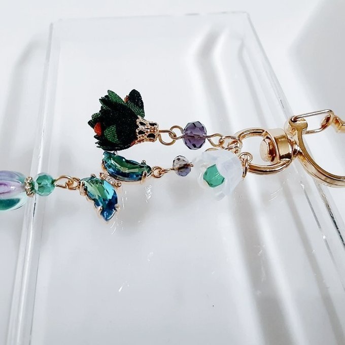 ブルーグリーン色のクリスタル蝶とフラワータッセルとすずらんビーズのお洒落キーホルダー
