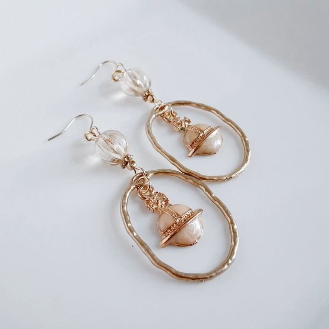 土星チャームが揺れるオーバルチャームとチェコビーズの大ぶりピアス/イヤリング(ライトベージュ)