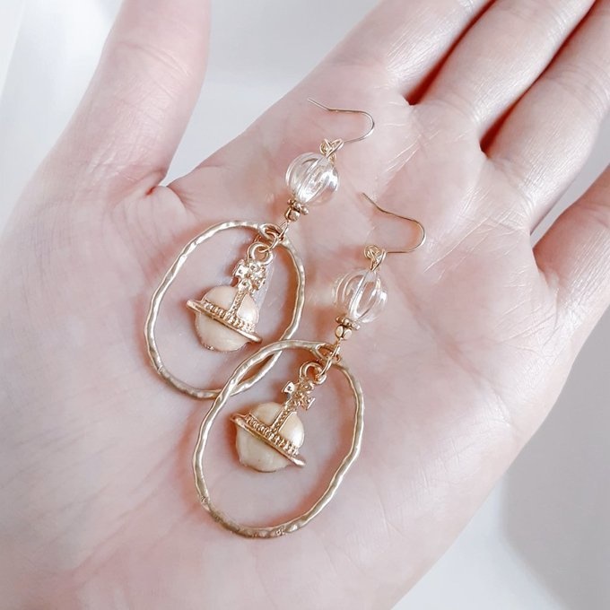 土星チャームが揺れるオーバルチャームとチェコビーズの大ぶりピアス/イヤリング(ライトベージュ)