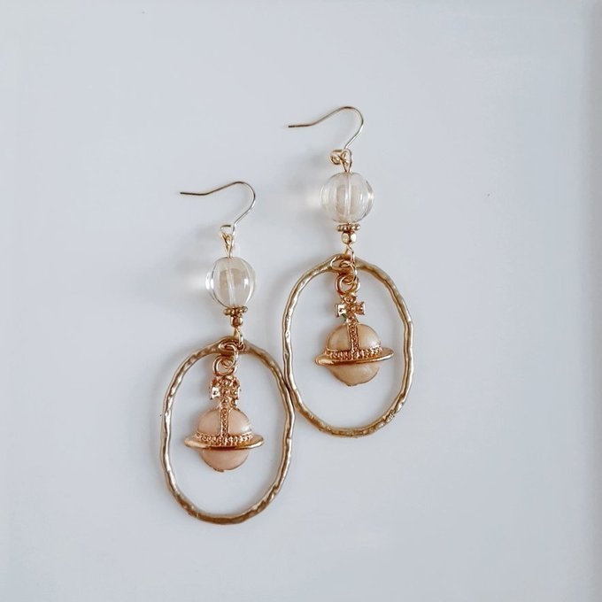 土星チャームが揺れるオーバルチャームとチェコビーズの大ぶりピアス/イヤリング(ライトベージュ)