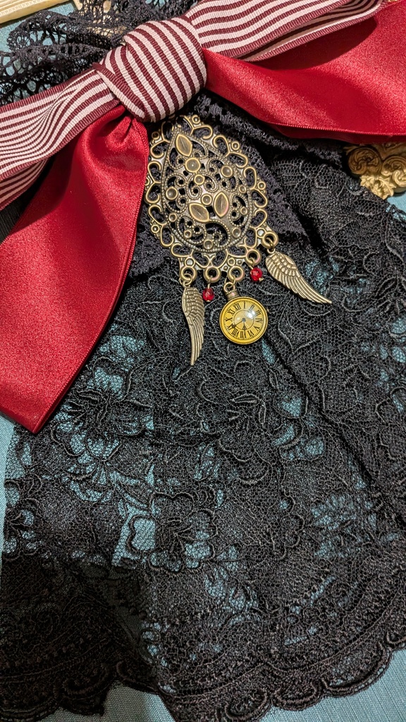 時を羽ばたくリボンジャボタイブローチ。