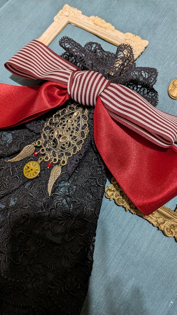 時を羽ばたくリボンジャボタイブローチ。