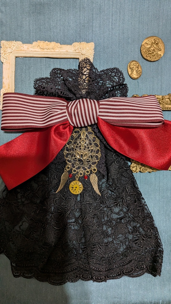 時を羽ばたくリボンジャボタイブローチ。