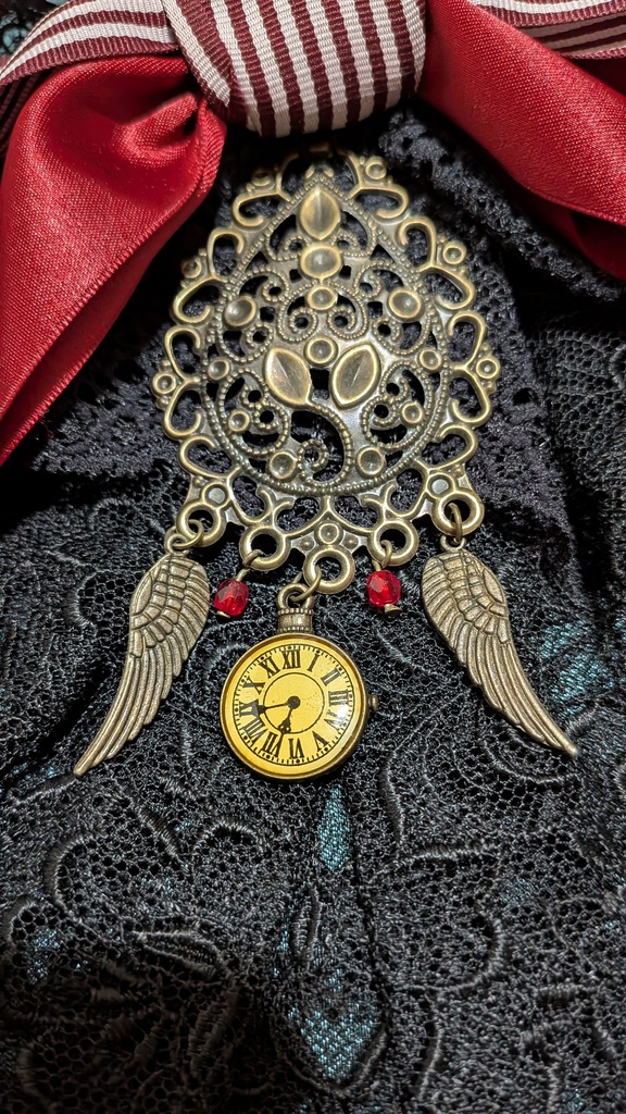 時を羽ばたくリボンジャボタイブローチ。