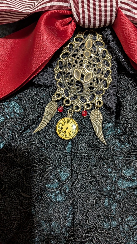 時を羽ばたくリボンジャボタイブローチ。