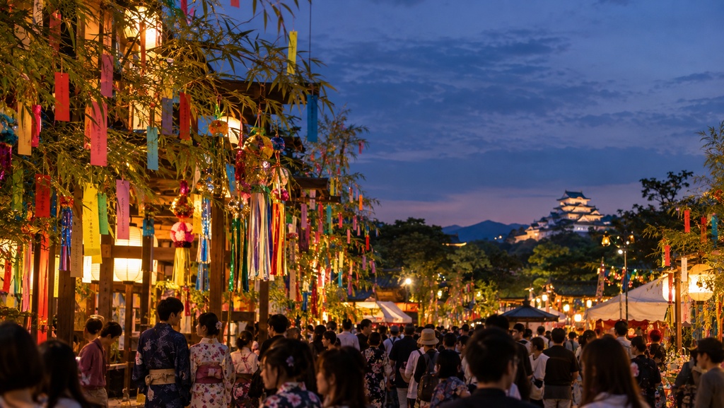 日本で人ごみの中七夕を祝う若夫婦
