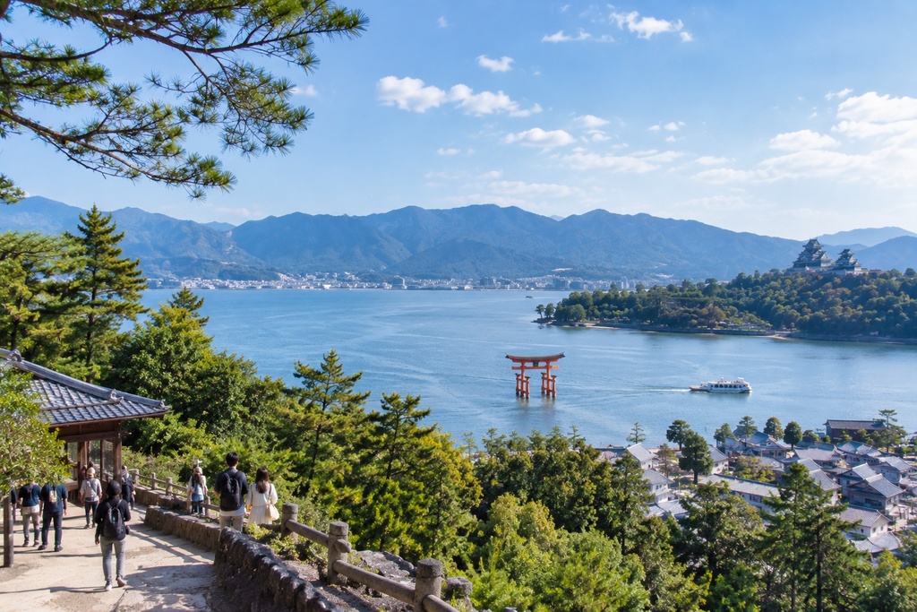 日本で人々がいる中、宮島を見下げる若夫婦
