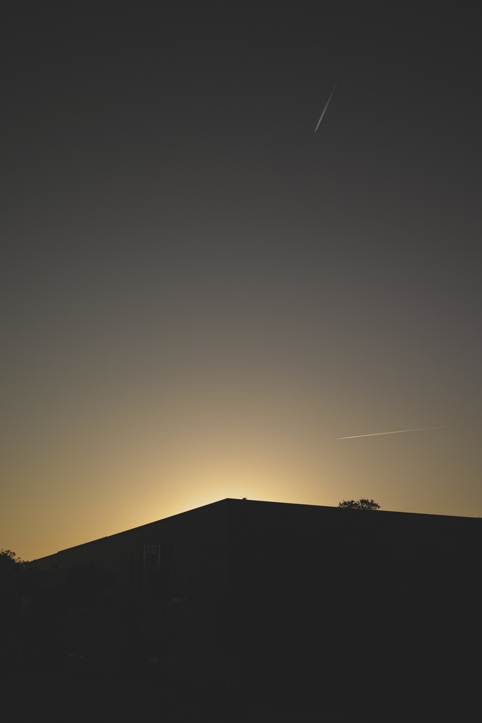 夕景の建物と二つの飛行機雲