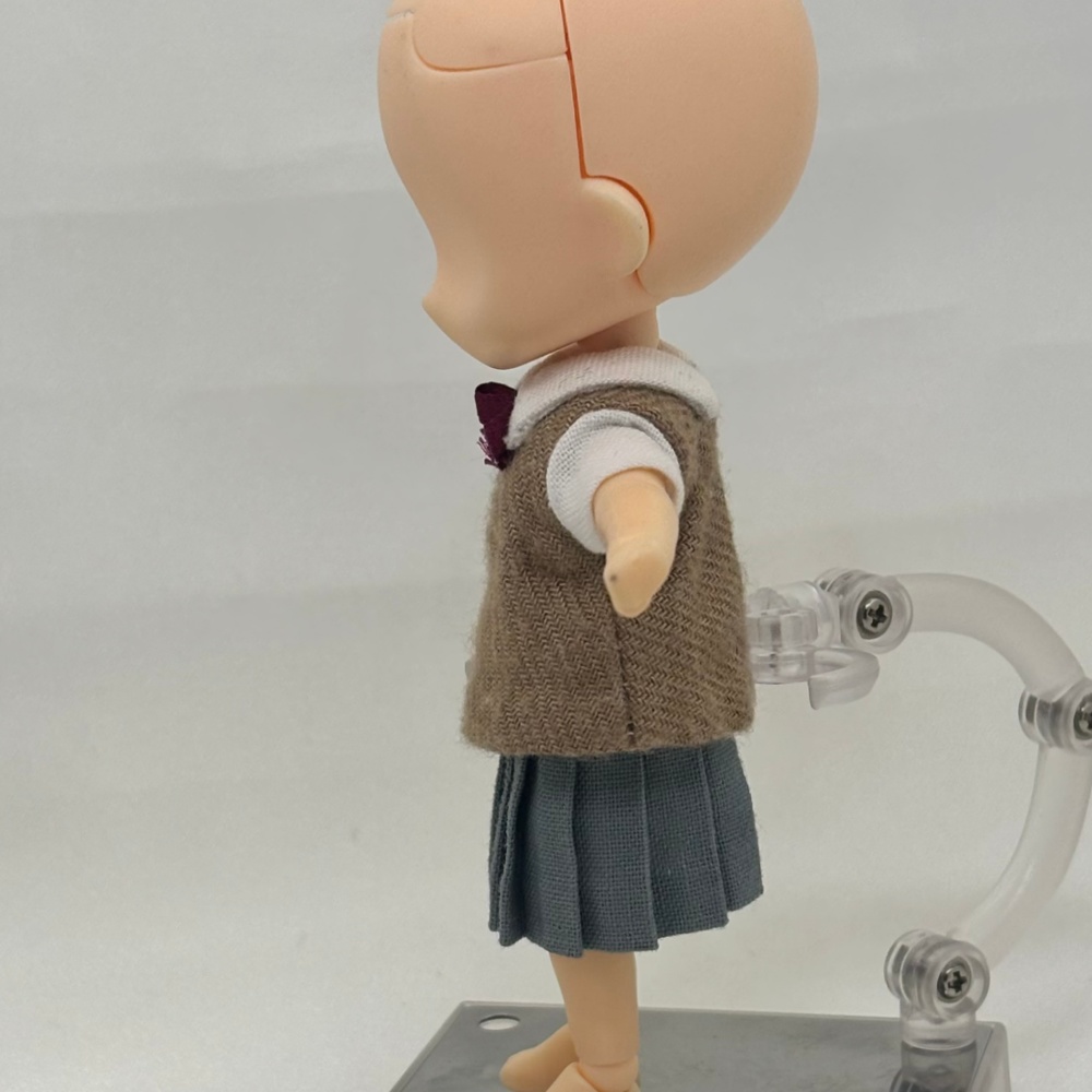 臙脂のリボンのベストとグレーのスカート