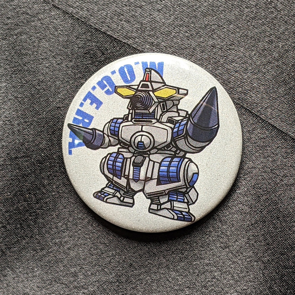 リフレクター缶バッチ　M.O.G.E.R.A.