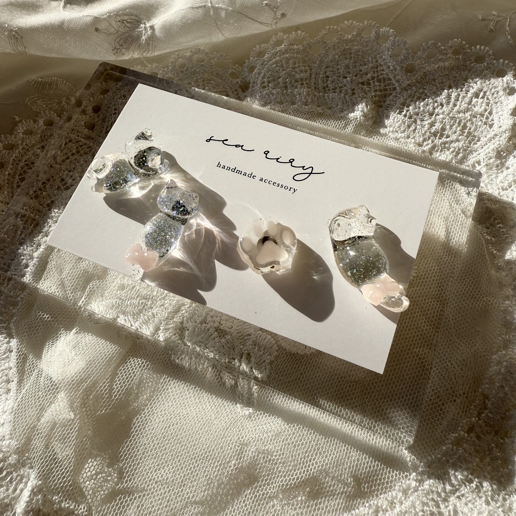 no.112 クリアラメのねこちゃん 淡色 さくら色 リボン 猫 肉きゅう サージカルステンレス ポストピアス