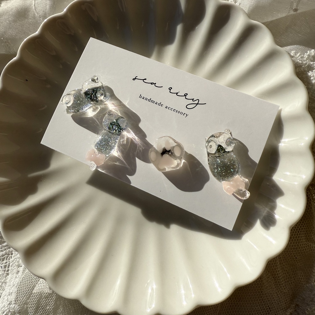 no.112 クリアラメのねこちゃん 淡色 さくら色 リボン 猫 肉きゅう サージカルステンレス ポストピアス