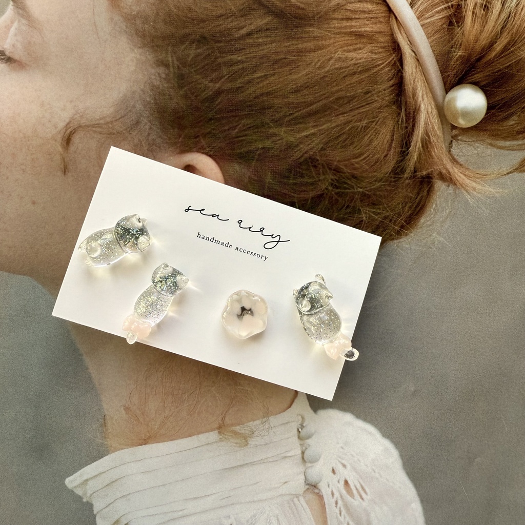 no.112 クリアラメのねこちゃん 淡色 さくら色 リボン 猫 肉きゅう サージカルステンレス ポストピアス