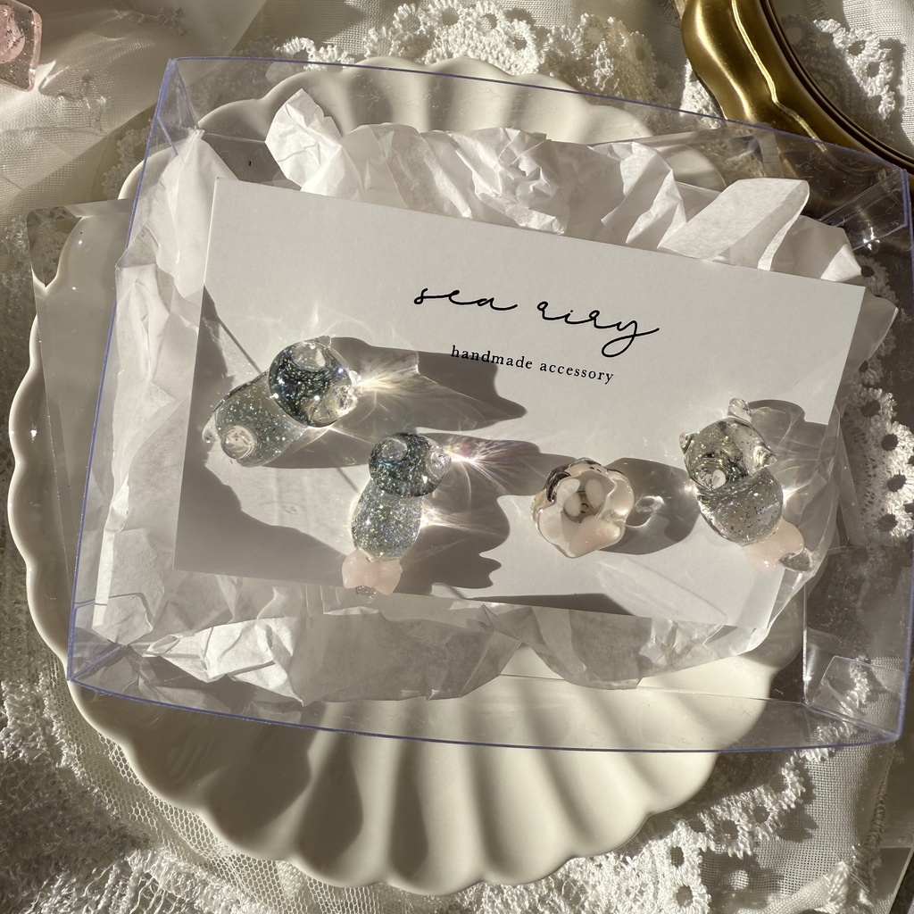 no.112 クリアラメのねこちゃん 淡色 さくら色 リボン 猫 肉きゅう サージカルステンレス ポストピアス