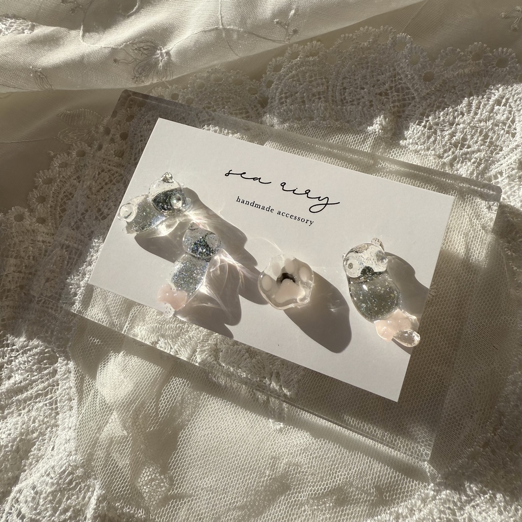 no.112 クリアラメのねこちゃん 淡色 さくら色 リボン 猫 肉きゅう サージカルステンレス ポストピアス