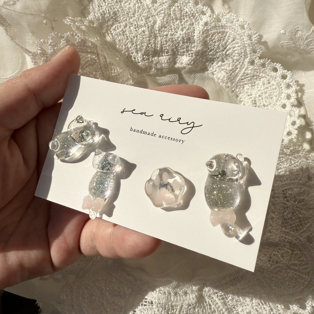 no.112 クリアラメのねこちゃん 淡色 さくら色 リボン 猫 肉きゅう サージカルステンレス ポストピアス