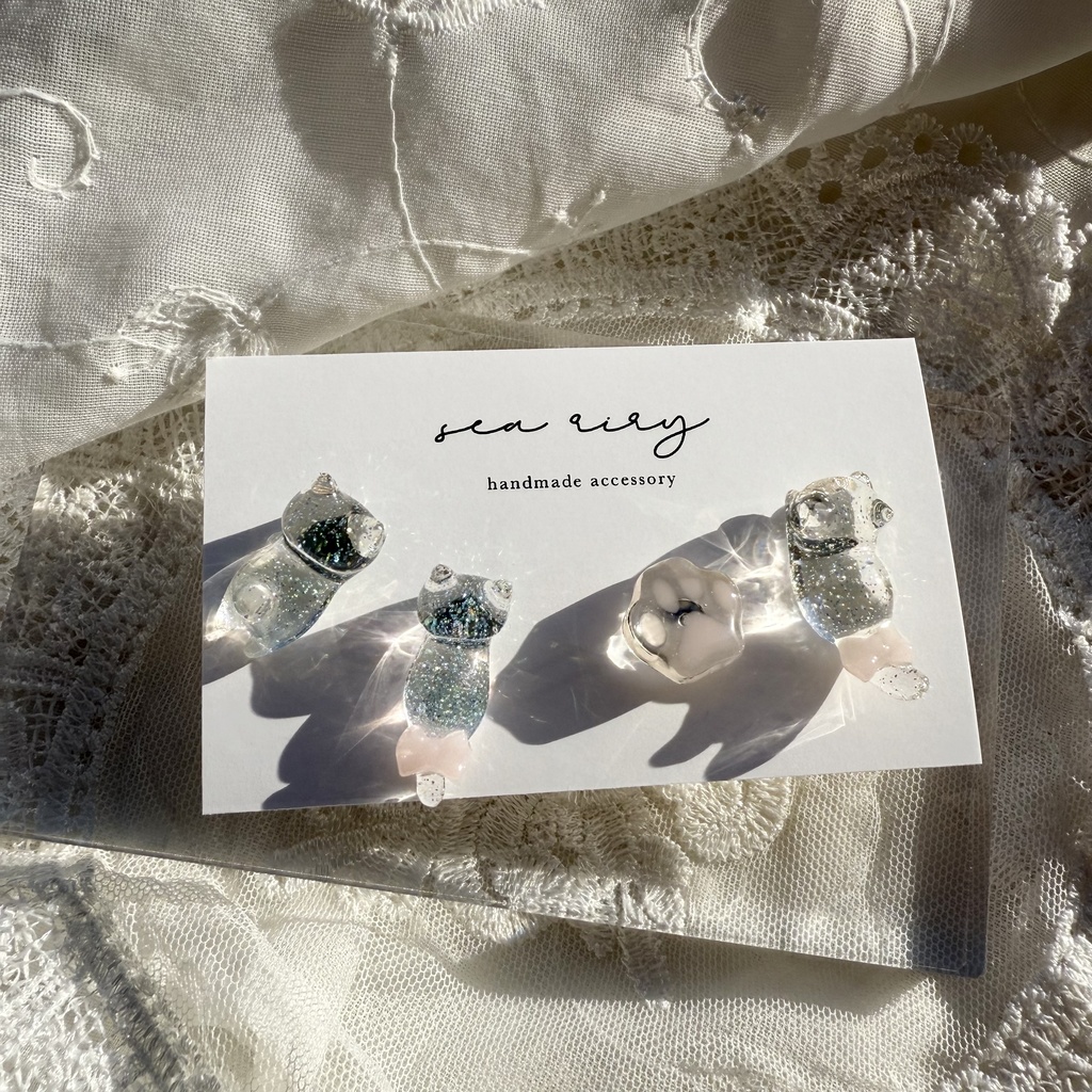 no.112 クリアラメのねこちゃん 淡色 さくら色 リボン 猫 肉きゅう サージカルステンレス ポストピアス