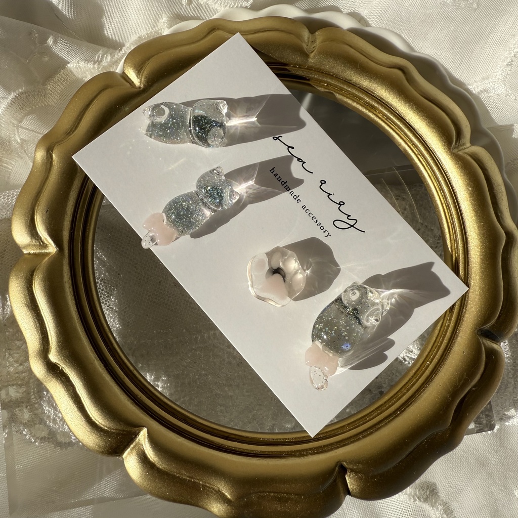 no.112 クリアラメのねこちゃん 淡色 さくら色 リボン 猫 肉きゅう サージカルステンレス ポストピアス