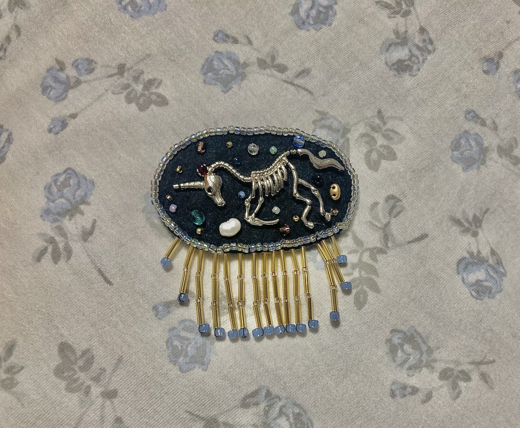 Unicorn fossil brooch