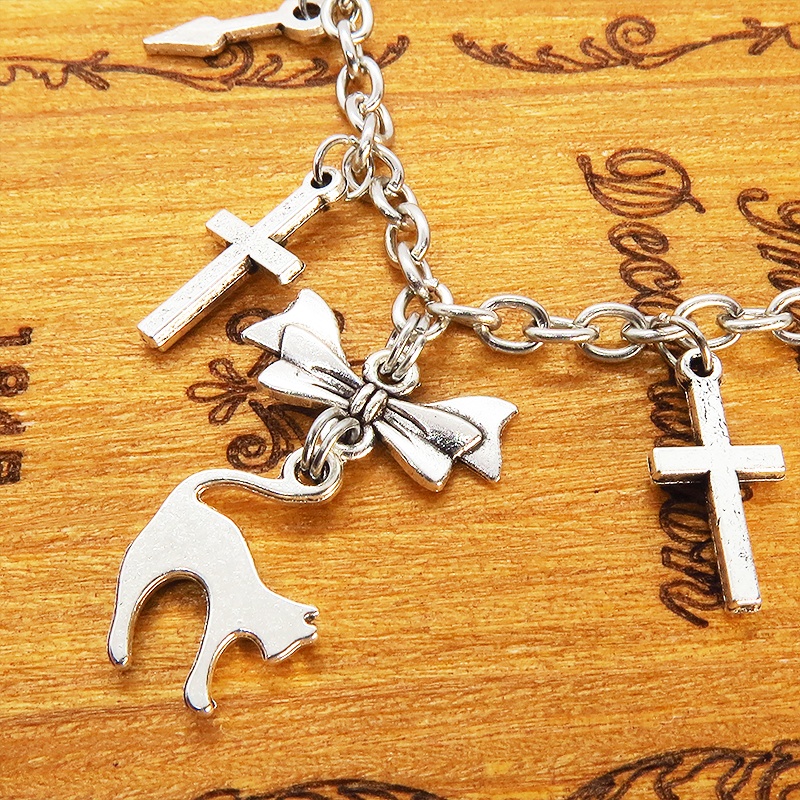 シルバーカラー 猫シルエットモチーフとリボンにロザリオと時計の針が連なるブレスレット