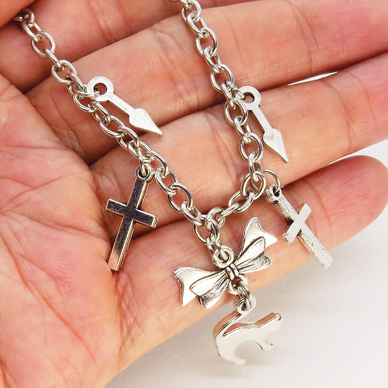 シルバーカラー 猫シルエットモチーフとリボンにロザリオと時計の針が連なるブレスレット