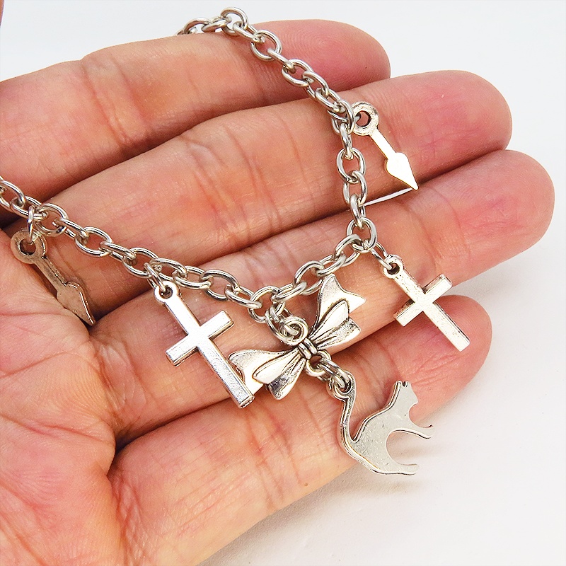 シルバーカラー 猫シルエットモチーフとリボンにロザリオと時計の針が連なるブレスレット