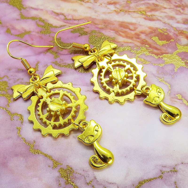 猫と歯車とリボンのユニークで華やかなピアス ゴールドカラー