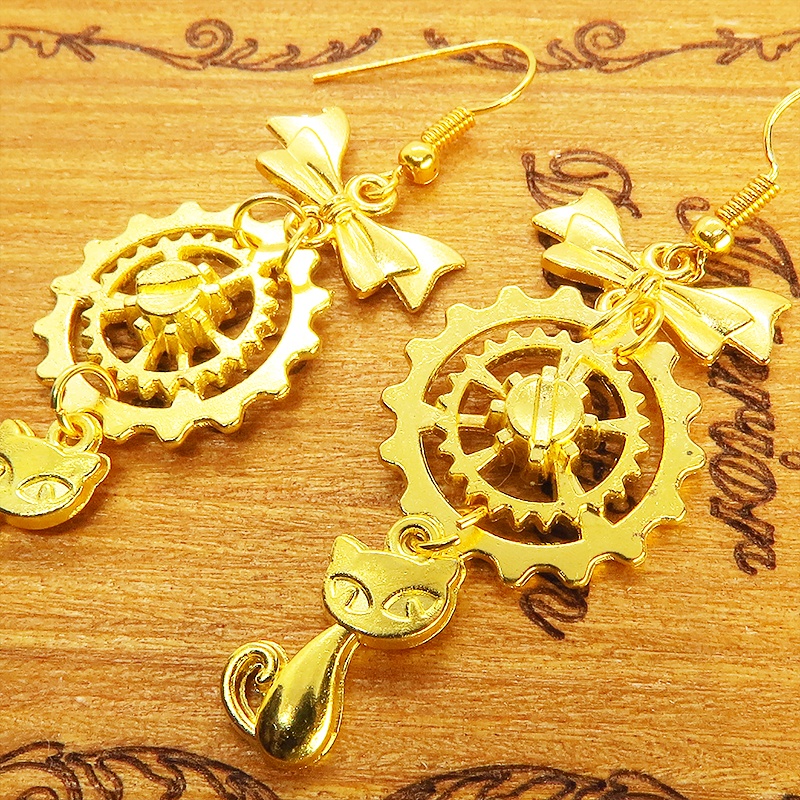 猫と歯車とリボンのユニークで華やかなピアス ゴールドカラー