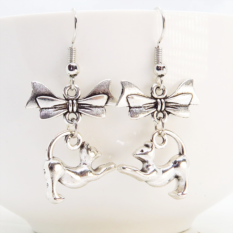 アンティークシルバー のび猫シルエットモチーフとリボンを組合せたコンパクトなピアス サージカル可