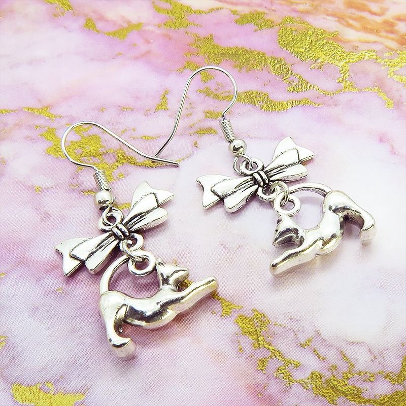アンティークシルバー のび猫シルエットモチーフとリボンを組合せたコンパクトなピアス サージカル可
