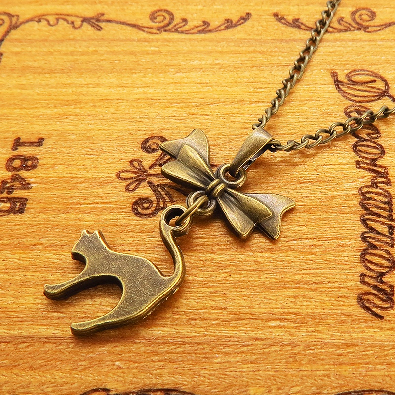 アンティークゴールド 跳ね猫とリボンのモチーフを組合せたコンパクトで大人可愛いネックレス 長さ変更可 アジャスター可