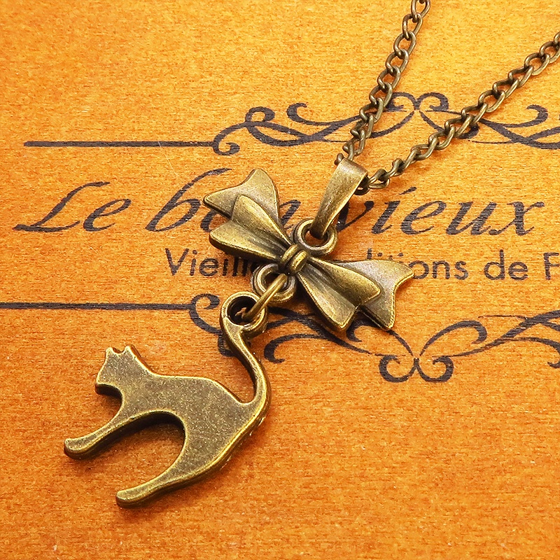 アンティークゴールド 跳ね猫とリボンのモチーフを組合せたコンパクトで大人可愛いネックレス 長さ変更可 アジャスター可