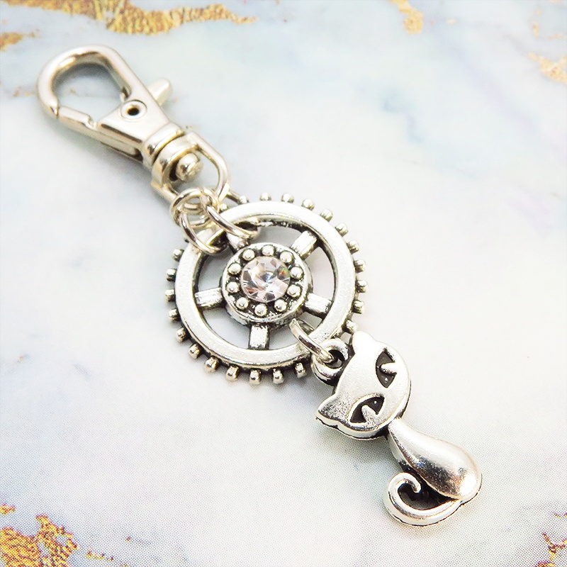 アンティークシルバー 猫と歯車を組合せた可愛いキーホルダー スワロフスキー・クリスタル バッグチャーム ファスナーチャーム