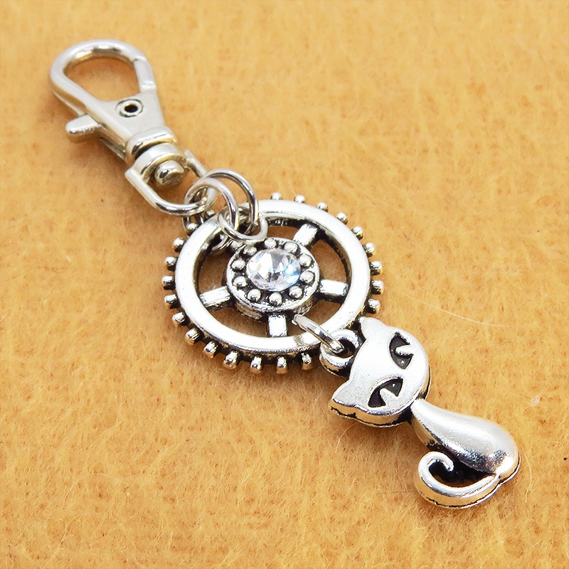 アンティークシルバー 猫と歯車を組合せた可愛いキーホルダー スワロフスキー・クリスタル バッグチャーム ファスナーチャーム
