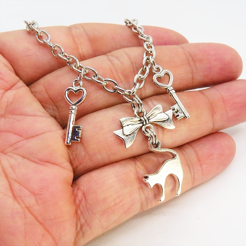 アンティークシルバー 跳ね猫シルエットモチーフとリボンに鍵が連なるブレスレット