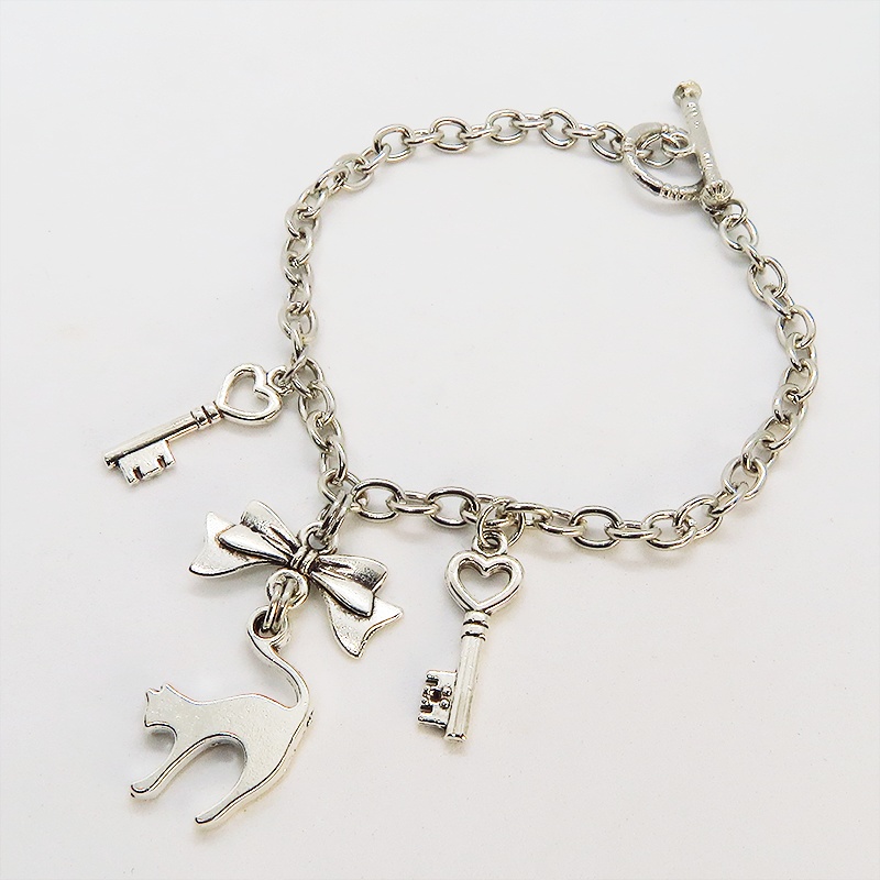 アンティークシルバー 跳ね猫シルエットモチーフとリボンに鍵が連なるブレスレット