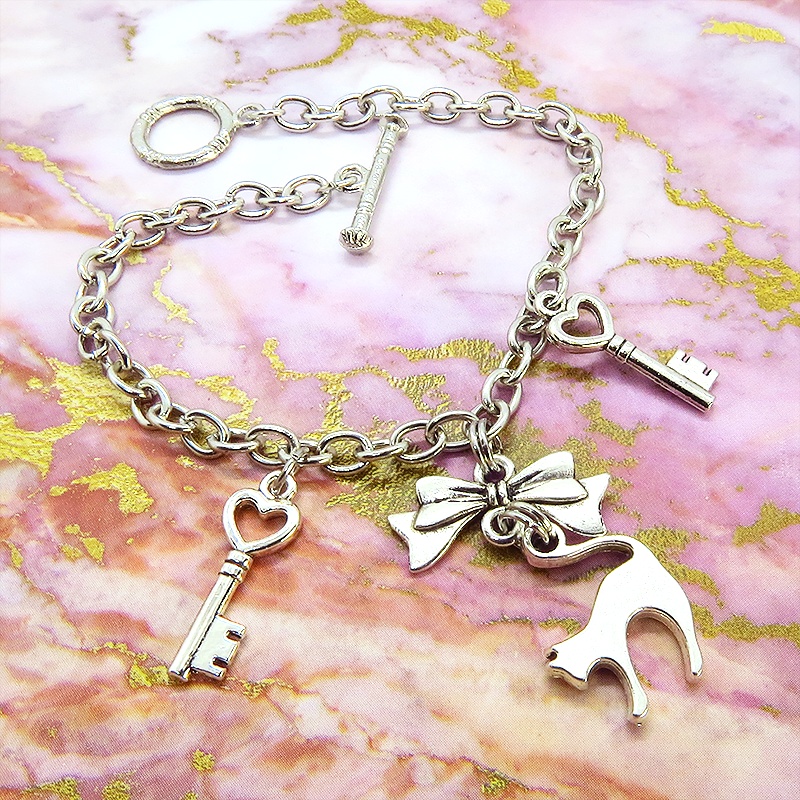 アンティークシルバー 跳ね猫シルエットモチーフとリボンに鍵が連なるブレスレット