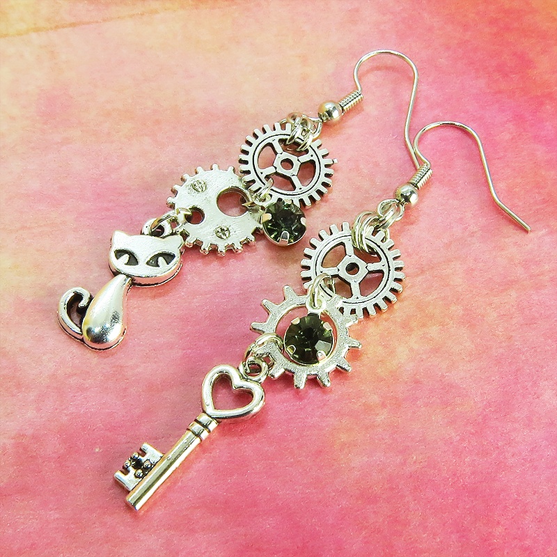 アンティークシルバー 猫と歯車・カギを組み合わせたスチームパンク風ピアス クリアガラス 深緑 サージカル可