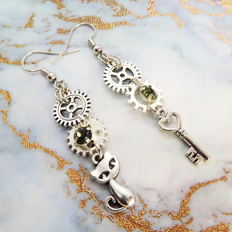 アンティークシルバー 猫と歯車・カギを組み合わせたスチームパンク風ピアス クリアガラス 深緑 サージカル可